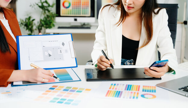 Creative female designers team using pen tablet and color palette working in graphic design Choose colors for working on tablets and computer designs. - Powered by Adobe