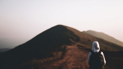 climbing. Solo hiker on mountain trail during golden hour, with blurred mountain backdrop. tourism brochures, itinerary planners, designed for hospitality marketing for hotel rooms and spa retreats.