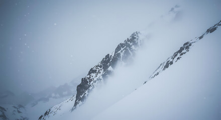 Snow covered mountain peaks shrouded in mist and fog winter