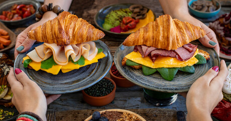 Croissant sandwich filled with ham, bacon, cheese and salad.  croisandwich