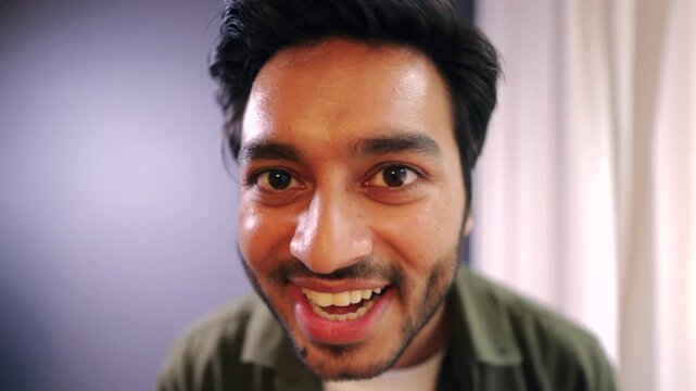 Young south asian man looking closely at his face skin in mirror showing concern about wrinkles fatigue or aging representing skincare selfcare and morning routine awareness in daily life