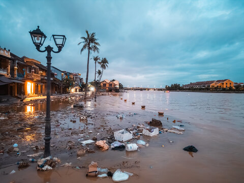 flooded city or town with buildings submerged in overflow water and mud, village underwater after heavy tropical rain and typhoon, consequences with dirt on the street