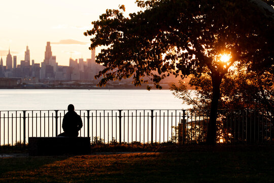 Person sitting at city viewpoint viewing the sunset
