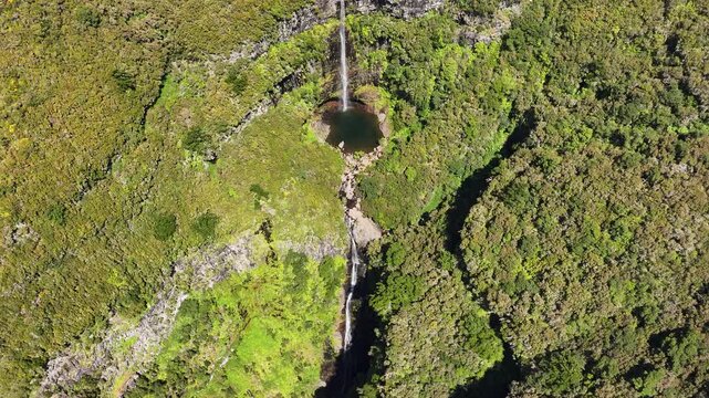 Drone pullback reveals scenic Risco falls in lush landscape of Madeira