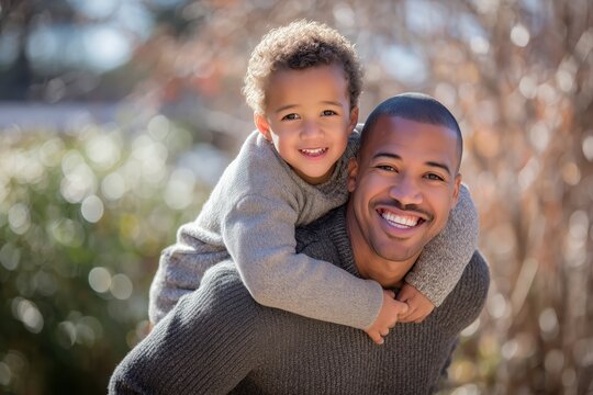 A father enjoying the outdoors while giving his son a piggyback ride - Powered by Adobe