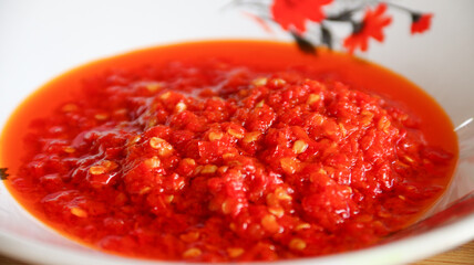 Sambal cabe merah or red chili sambal in Padang restaurant. served on red plate