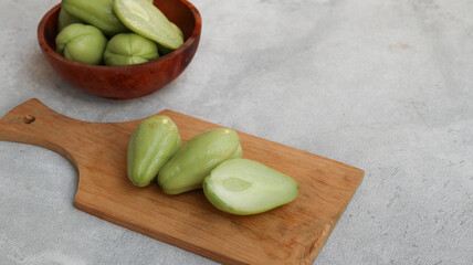 baby chayote (labu siam) on wooden cutting board isolated on grey background	
