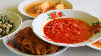 Sambal cabe merah or red chili sambal in Padang restaurant. served on red plate