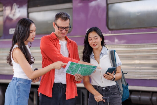 Travelers discussing travel plan using map at train station platform
