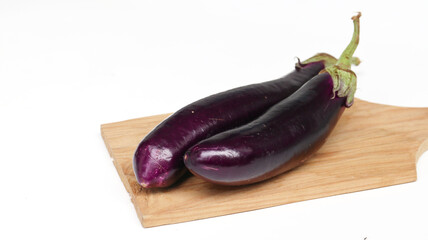 fresh raw healthy eggplants or aubergine vegetable on wooden cutting board. Food ingredient, vegetatian cuisine, organic greenhouse farm plant