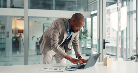 Typing, businessman and laptop in office, paperwork and financial analysis on web, research and info. Investment banker, black person and plan for pitch with tech, documents and checking market data