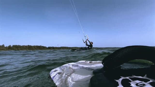 Kitesurfer Riding in the Ocean with Blue Sky and Kites Background