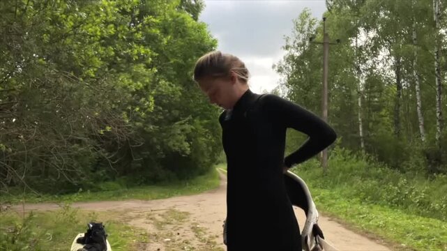 Woman preparing to kitesurf, adjusting harness and Warrior Waist