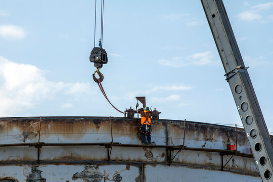 Steel workers construct a storage tank
