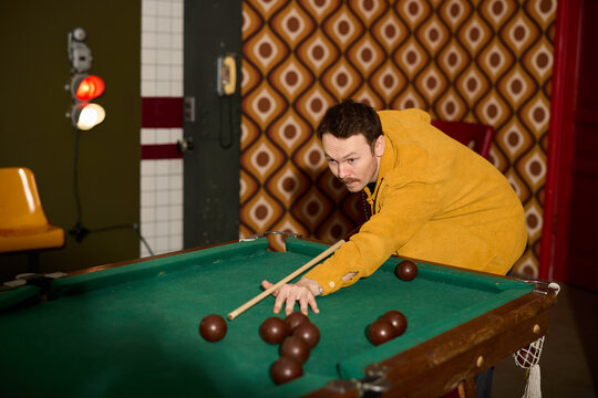 Playing pool in a retro-themed room with vibrant colors