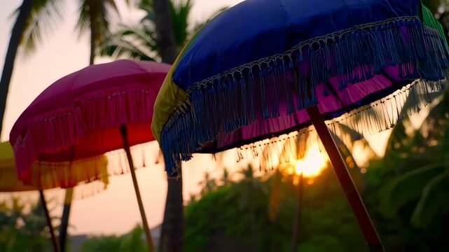 Vivid, fringed parasols stand at sunset amid palm trees, capturing the essence of paradise