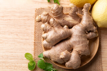 Fresh ginger and lemon on wooden background, Table top view