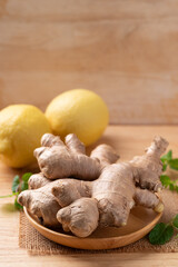 Fresh ginger and lemon on wooden background