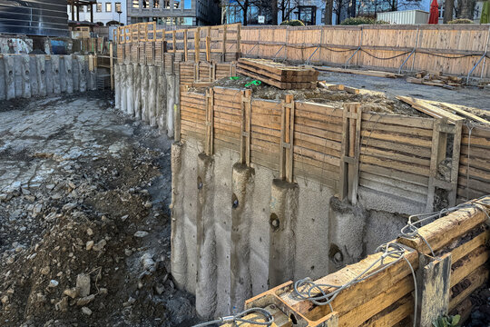 Construction site showing deep excavation with retaining walls
