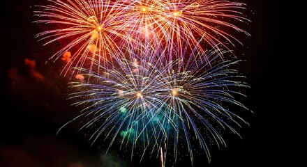Spectacular burst of colorful fireworks illuminating the dark night sky with vibrant explosions of light