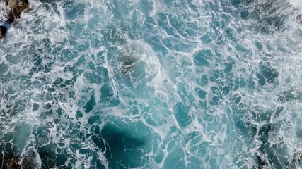 Top aerial view of rocky cliff, waves crashing with great splashing and white foam - Powered by Adobe