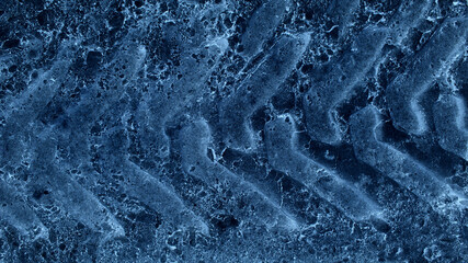 A pattern of heavy vehicle tire marks on a blue snow-like surface 
