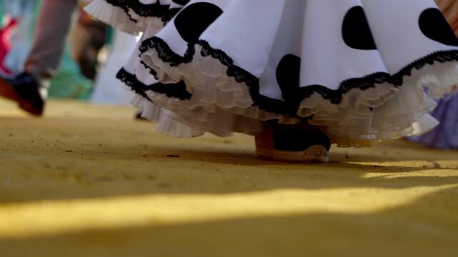 Traditional flamenco shoes and dresses stamping rhythm on the Feria ground
