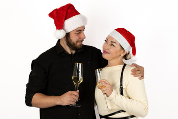 A happy couple in Santa hats is toasting with champagne to celebrate Christmas