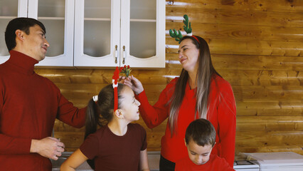 The family is happily baking Christmas cookies together in the kitchen