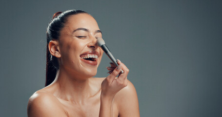 Woman, brush and excited in studio for makeup, contouring and tickle nose with beauty. Person,...