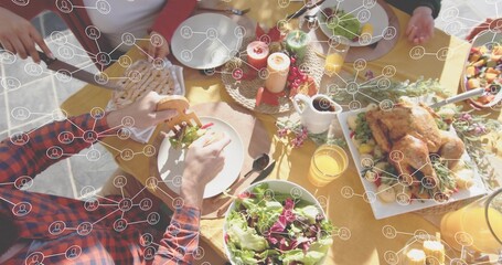 Serving dining group passing dishes at patio table, with roast bird, salad, plaid shirt, overlay