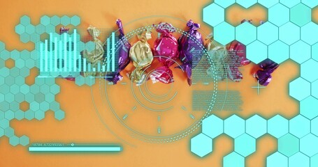 Fototapeta premium Displaying foil-wrapped candies shimmering in studio flat-lay on orange surface, with turquoise HUD