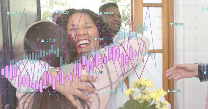 Hugging five adults embracing central woman laughing near wooden door, showing financial overlay