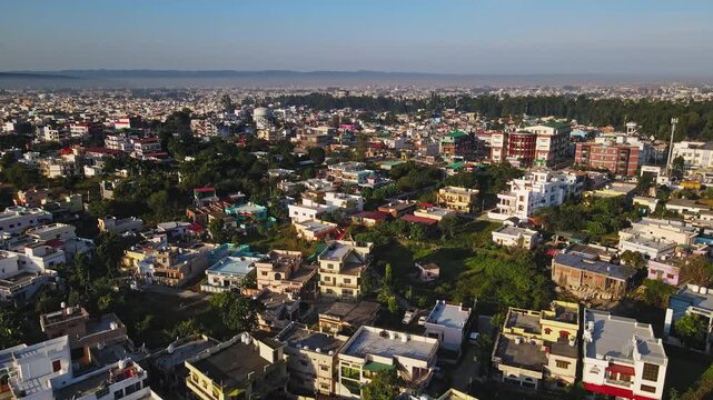 An aerial view of Dehradun, an Indian city during sunrise or sunset, with cloudy weather and rows of residential houses.
