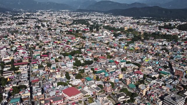 An aerial view of Dehradun, an Indian city during sunrise or sunset, with cloudy weather and rows of residential houses.