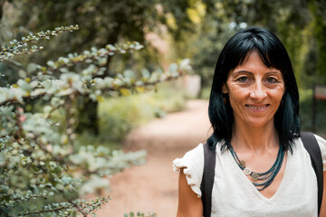 Smiling woman in forest, close-up portrait on nature path