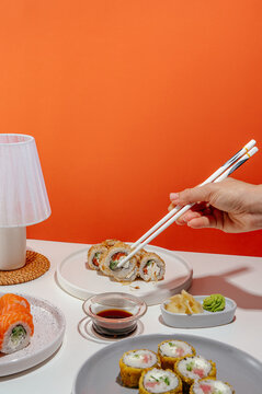 sushi set with chopsticks in hand on a bright background