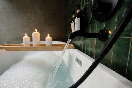 Bathtub filling with water and bubbles for a relaxing spa - Powered by Adobe