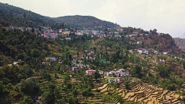 Daytime Aerial view of traditional Himalayan Village in Uttarakhand, India with Mountain Landscape. Shot of terraced farms and uttarakhand village