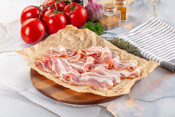Sliced pork bacon over board