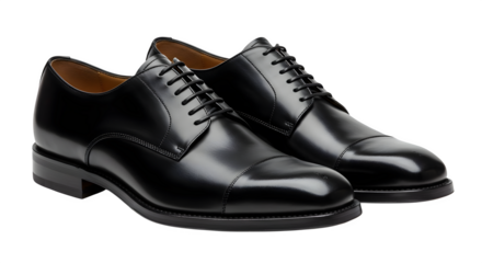 A pair of shiny black leather oxford shoes with laces on a dark background in a studio setting
