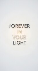 Inspirational quote displayed on a plain white wall with metallic and pastel-colored letters that read 'Forever in Your Light' in a modern and minimalist style