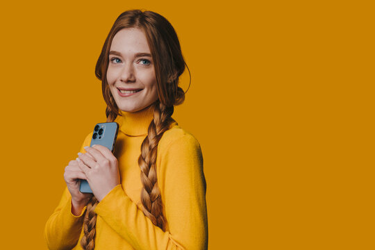 Female professional with braided hair and earbuds posing confidently