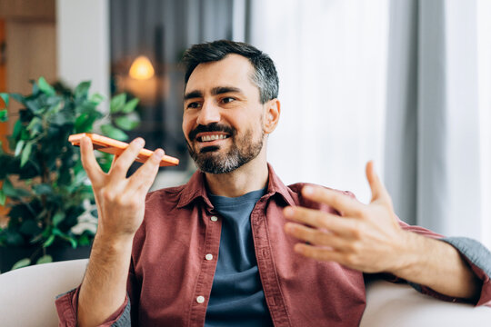 Man recording voice message on smartphone at home