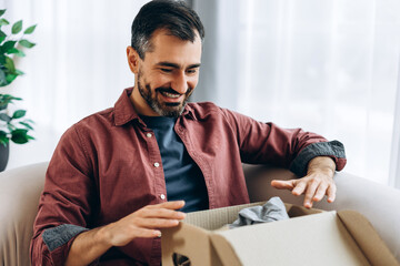 Fototapeta premium Happy man unboxing online shopping delivery box parcel