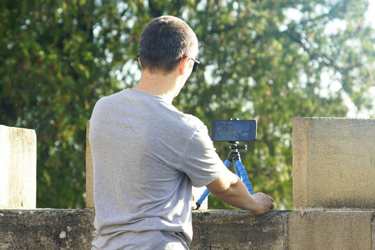 Man filming himself using tripod-mounted phone at Kalemegdan Fortress in Belgrade, Serbia. Symbol of solo content creation, cultural travel vlogging, Balkan tourism, and self-guided storytelling.