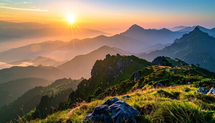 Sun bursts over misty mountain range, casting golden glow on grassy ridges in scenic, panoramic landscape