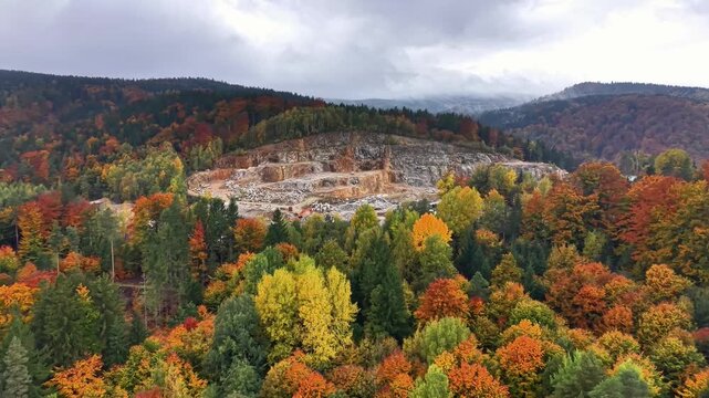 Rock terraces amid fall foliage, Aerial view of quarry carved into hillside with contrasting natural and manmade