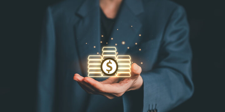 Businessman hand holding glowing gold bars and dollar sign icon, symbolizing financial success, investment strategy, and wealth accumulation in digital finance.