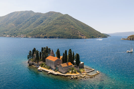 Aerial view of the islet of Sveti Dorde, a jewel with its ancient church, stands serene against the backdrop of the dramatic mountains, Perast, Kotor Municipality, Montenegro.